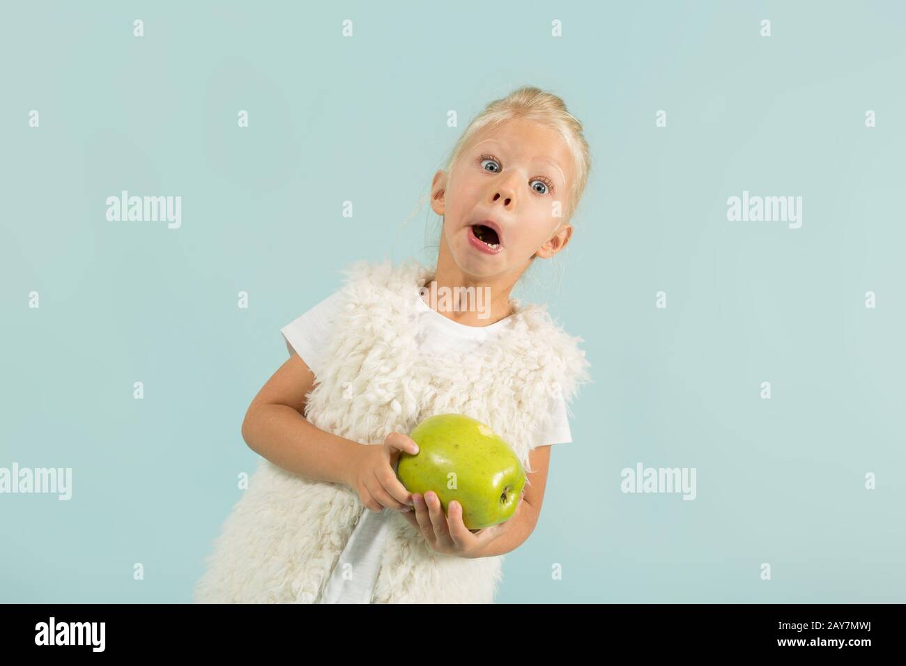 Hübsches, niedliches Mädchen in leichter Kleidung hält Äpfel Stockfoto