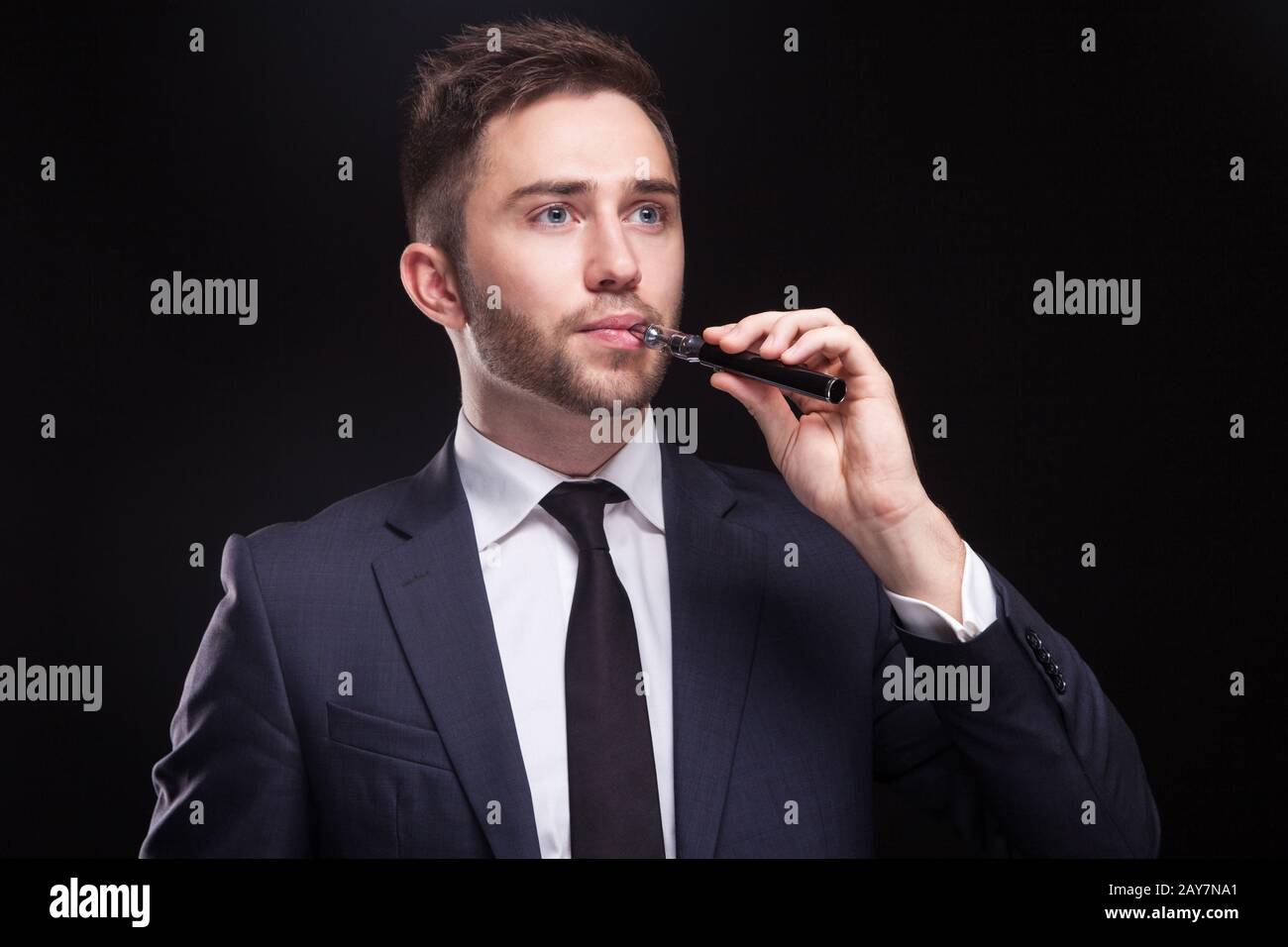 Bild eines ernsthaften Geschäftsmannes, der mit einem Vaping-Gerät steht Stockfoto