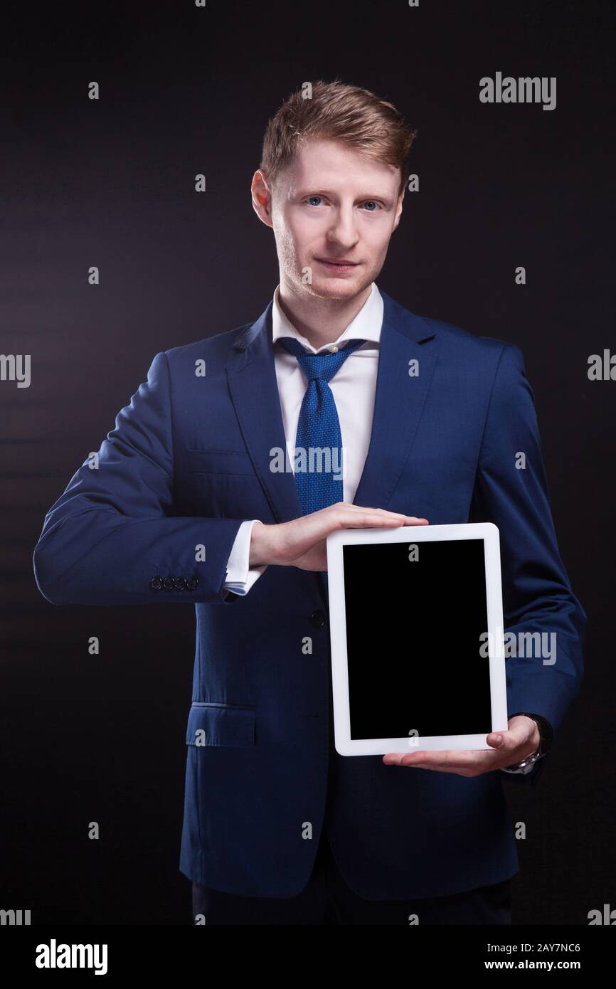 Ein Bild von einem ernsthaften Unternehmer, der mit einem Tablet steht Stockfoto