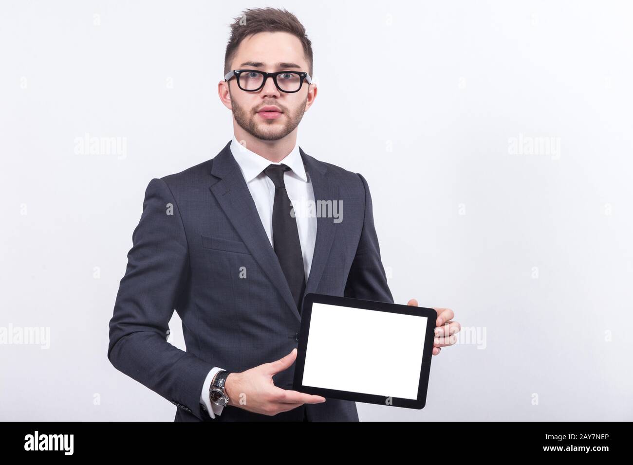 Ein Bild von einem ernsthaften Unternehmer, der mit einem Tablet steht Stockfoto