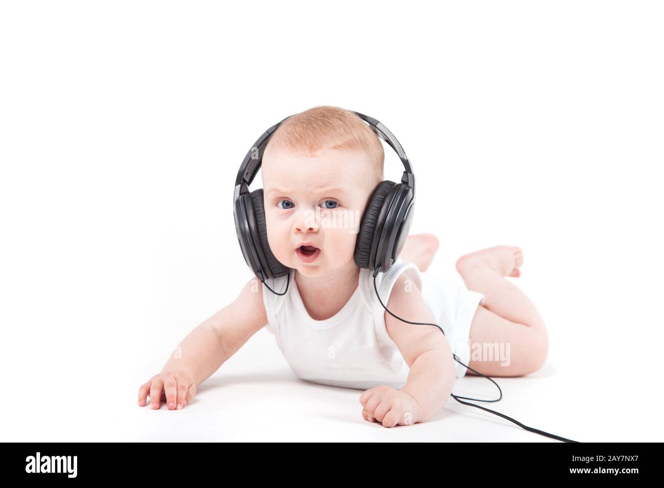 Schwere cute baby boy liegt mit Kopfhörern Stockfoto