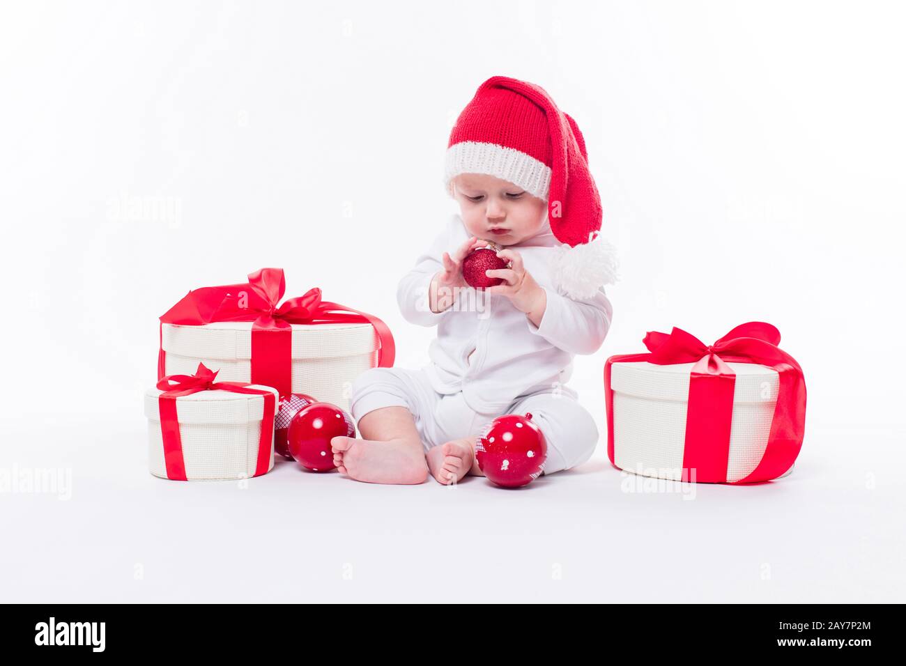 Schönes Baby in der Neujahrskappe und weißer Körper sitzt unter B. Stockfoto