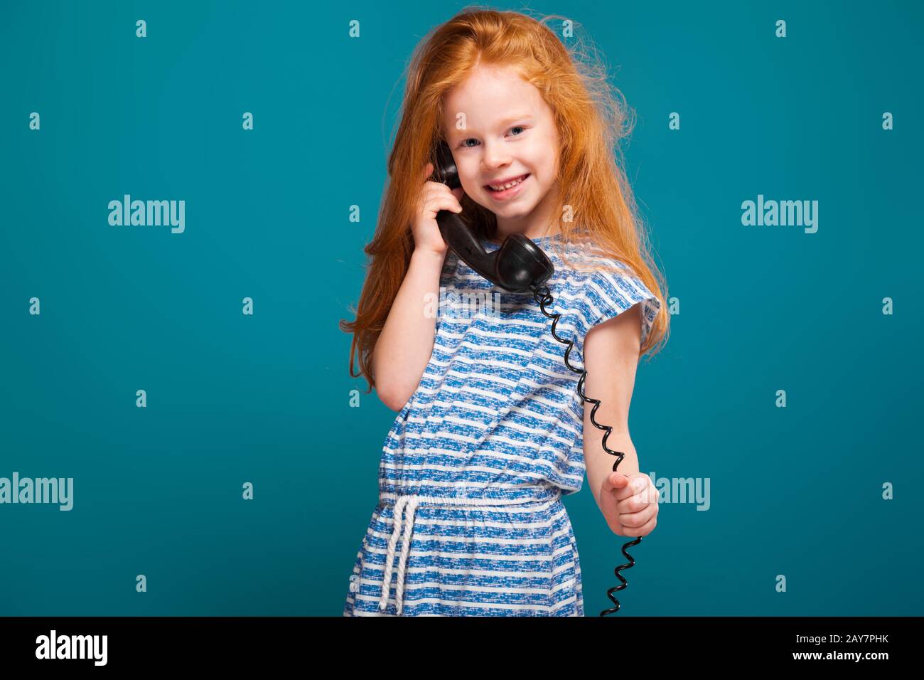 Schönheit kleines Mädchen im T-Shirt mit langen Haaren sprechen ein Telefon Stockfoto