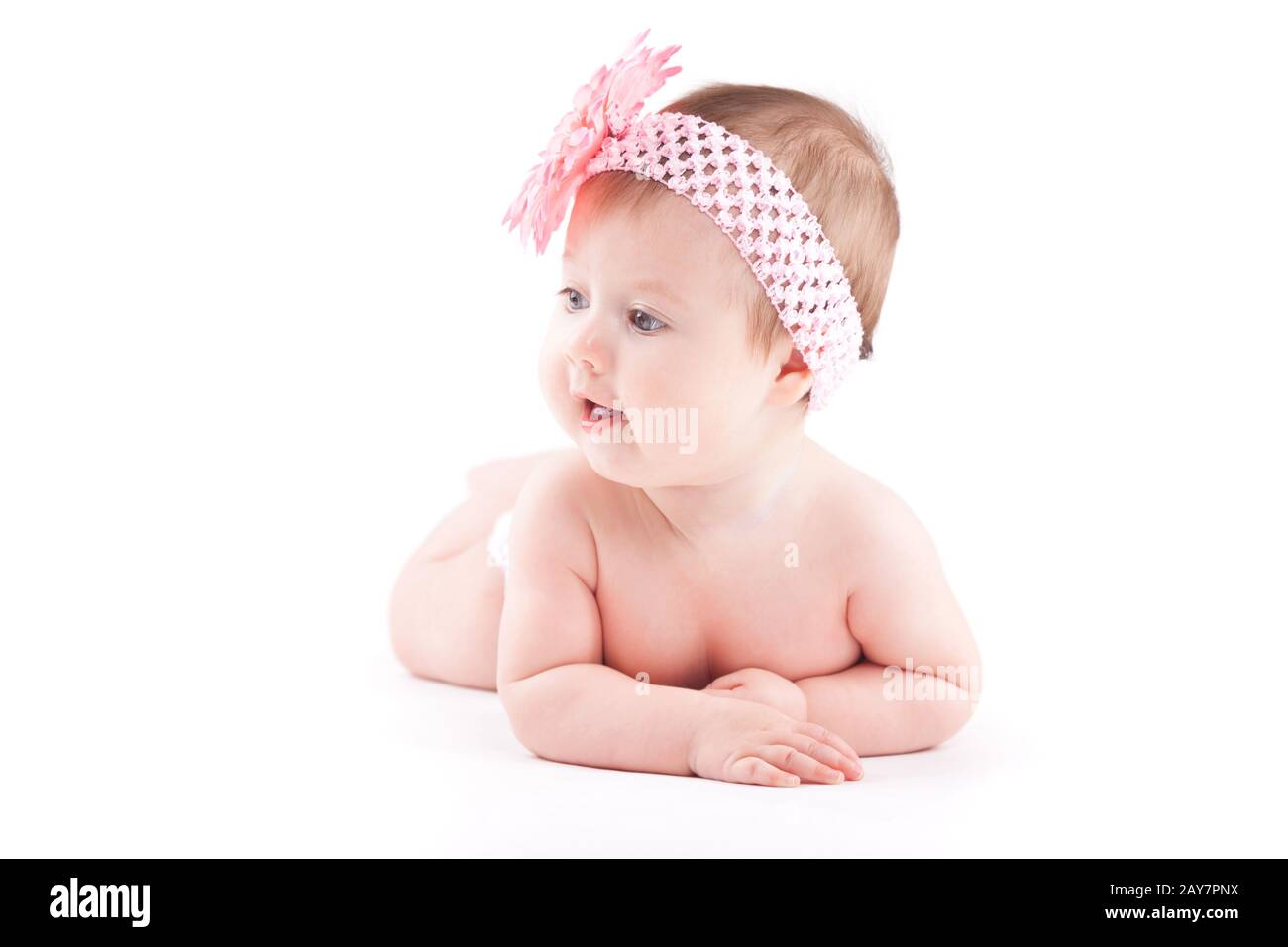 Beautiful Baby Mädchen in rosa Blume wrap liegt auf Bauch Stockfoto