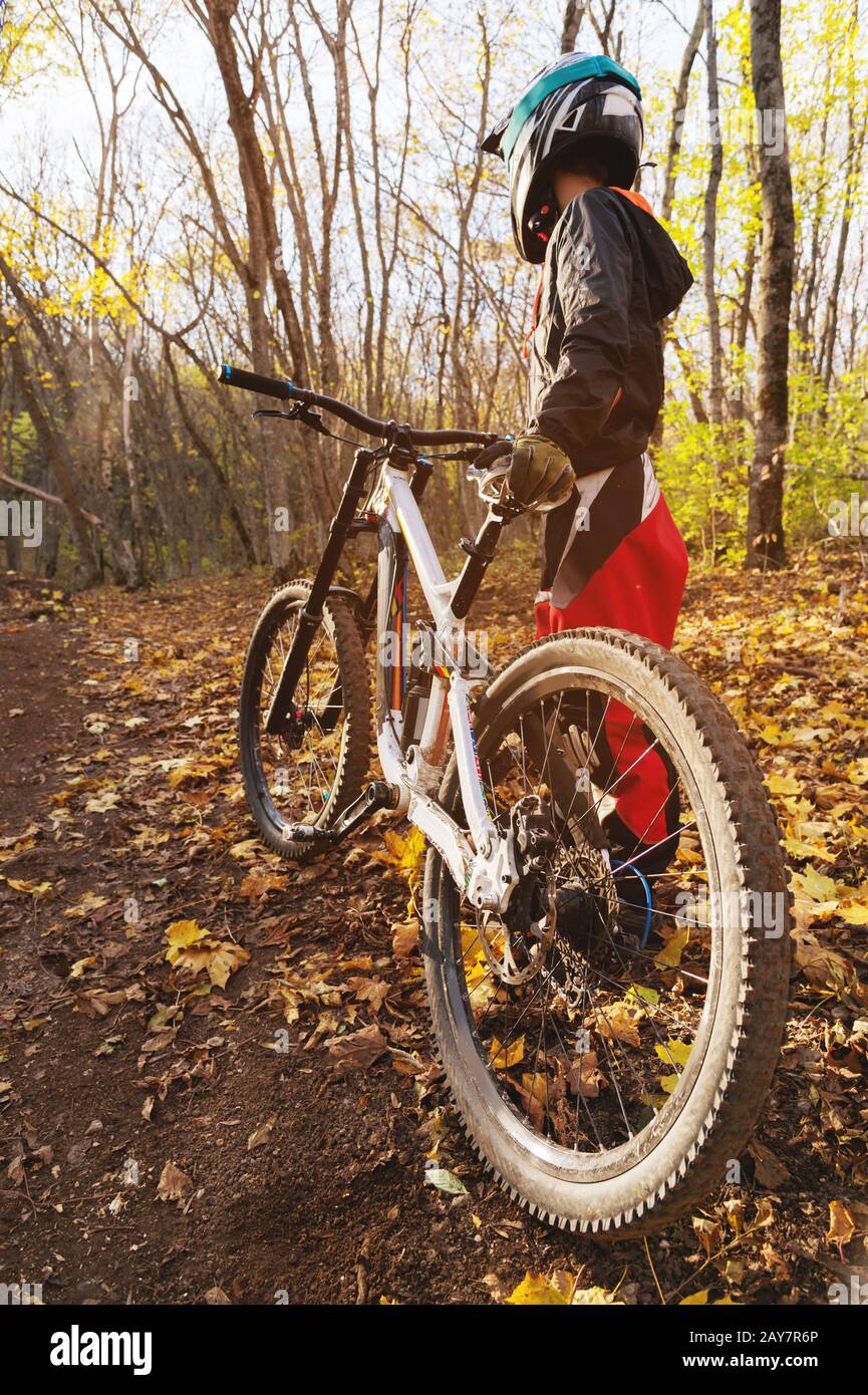 Porträt eines jungen Fahrers in vollem Schutz einer Gesichtshelmmaske und Handschuhe auf einem Fahrrad Stockfoto