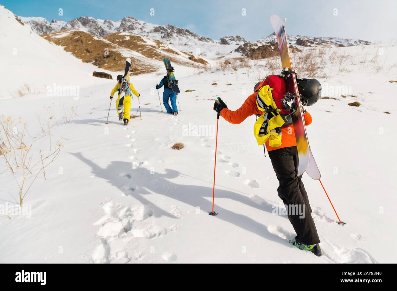 Eine Gruppe von drei Freeridern erklimmen den Berg für den Backcountry Ski entlang der wilden Pisten des Stockfoto