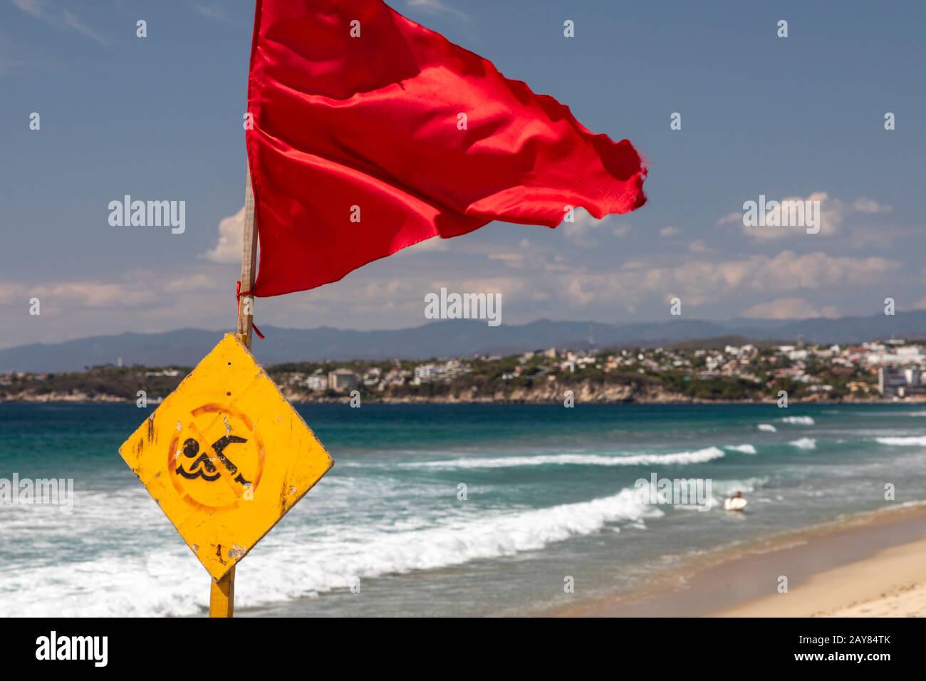 Leuchtende rote Warnfahne am unberührten Leblon-Strand mit Meer im