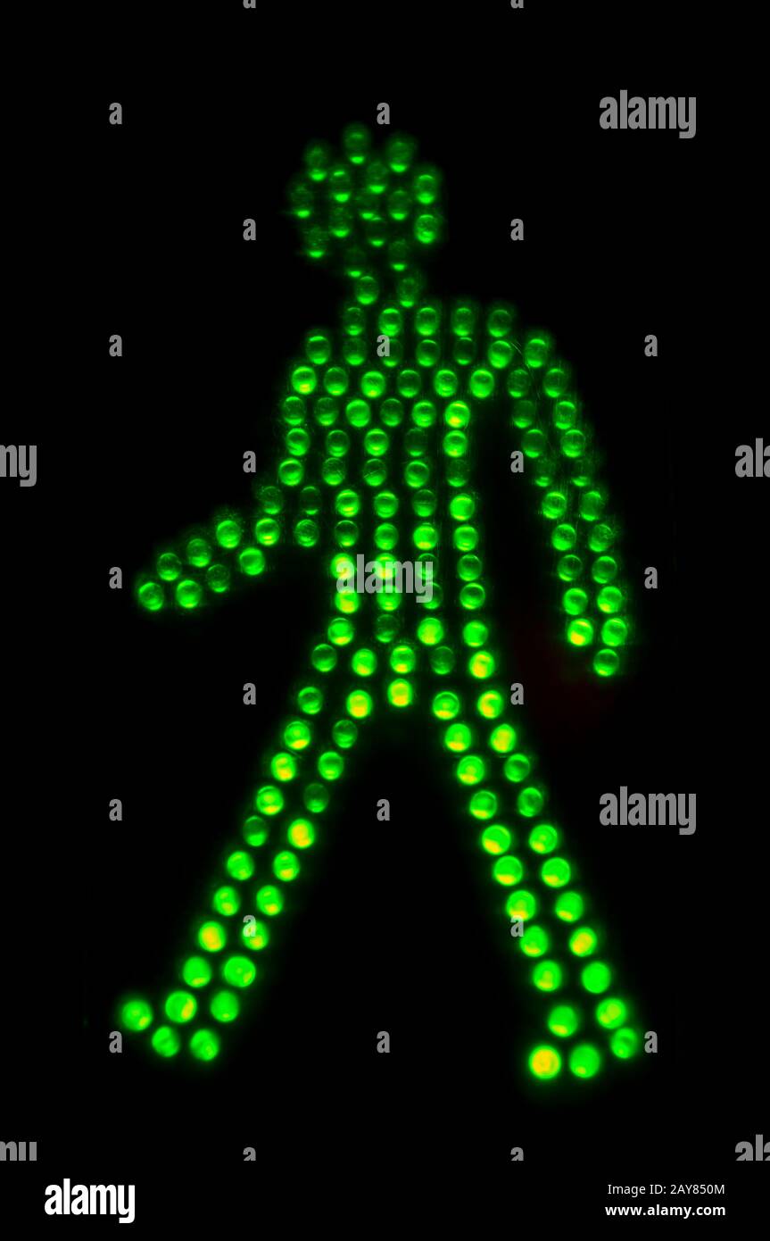 Grünes Licht des Hinweisschildes zum Fußgängerübergang auf schwarzem Grund Stockfoto