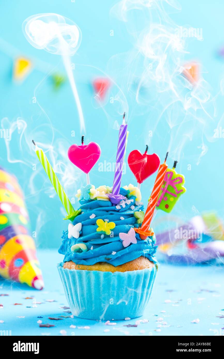 Bunt dekorierter Cupcake mit Kerzen brennt auf Stockfoto