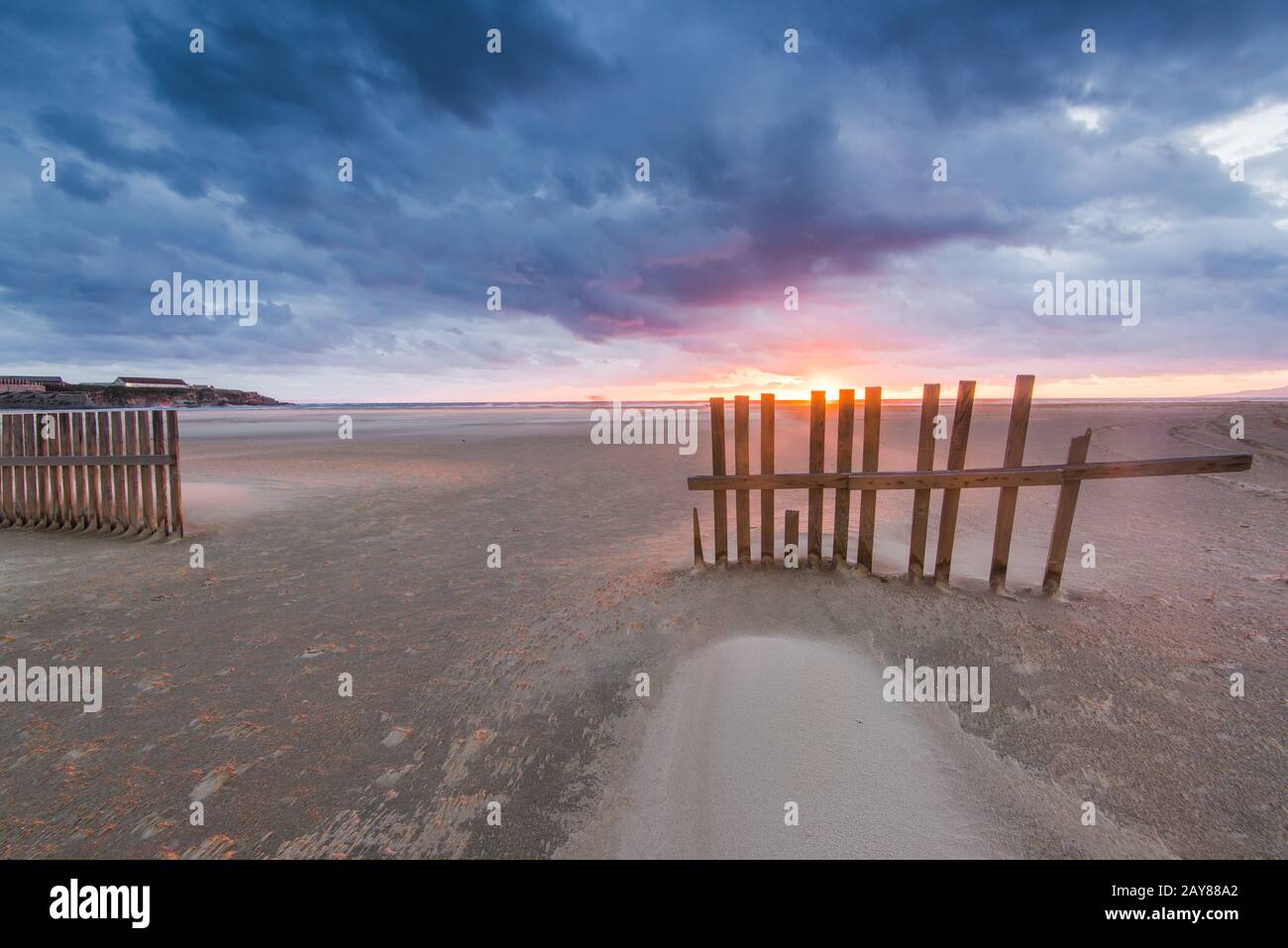 Wind bläst Sand am Strand von Tarifa in Spanien bei Sonnenuntergang Stockfoto