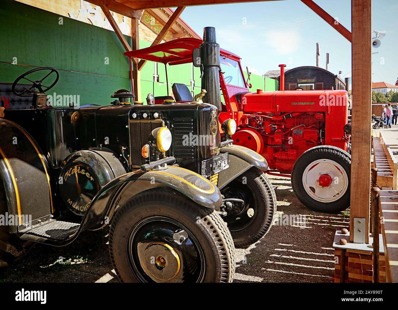 München, DEUTSCHLAND Lanz Bulldog Oldtimer und eine rote Deutz-Maschine auf der Oide Wiesn Historical Teil des Oktoberfests in München, eine Familie und Stockfoto