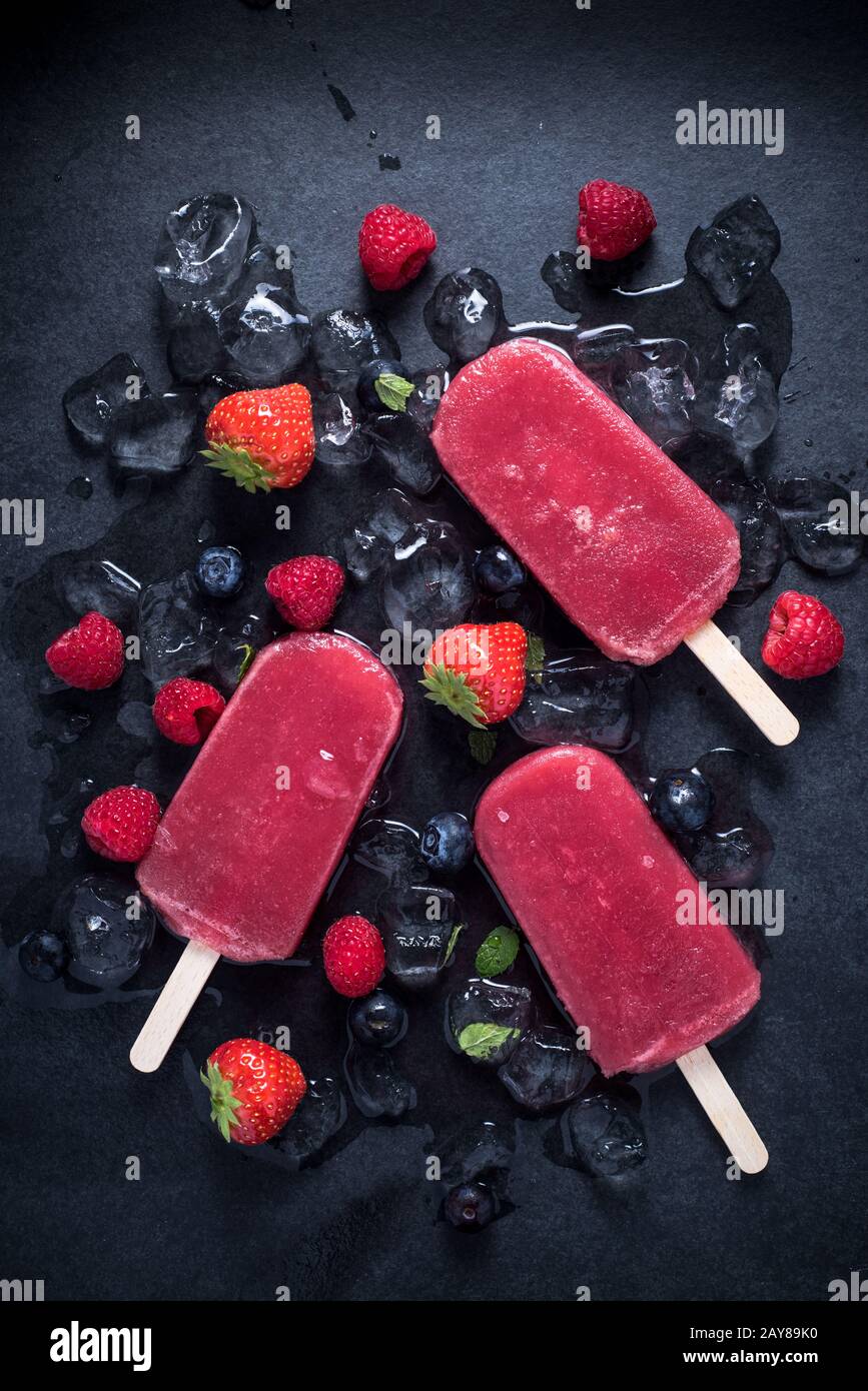 Erfrischender Popsicle auf Eiswürfeln und Früchten Stockfoto