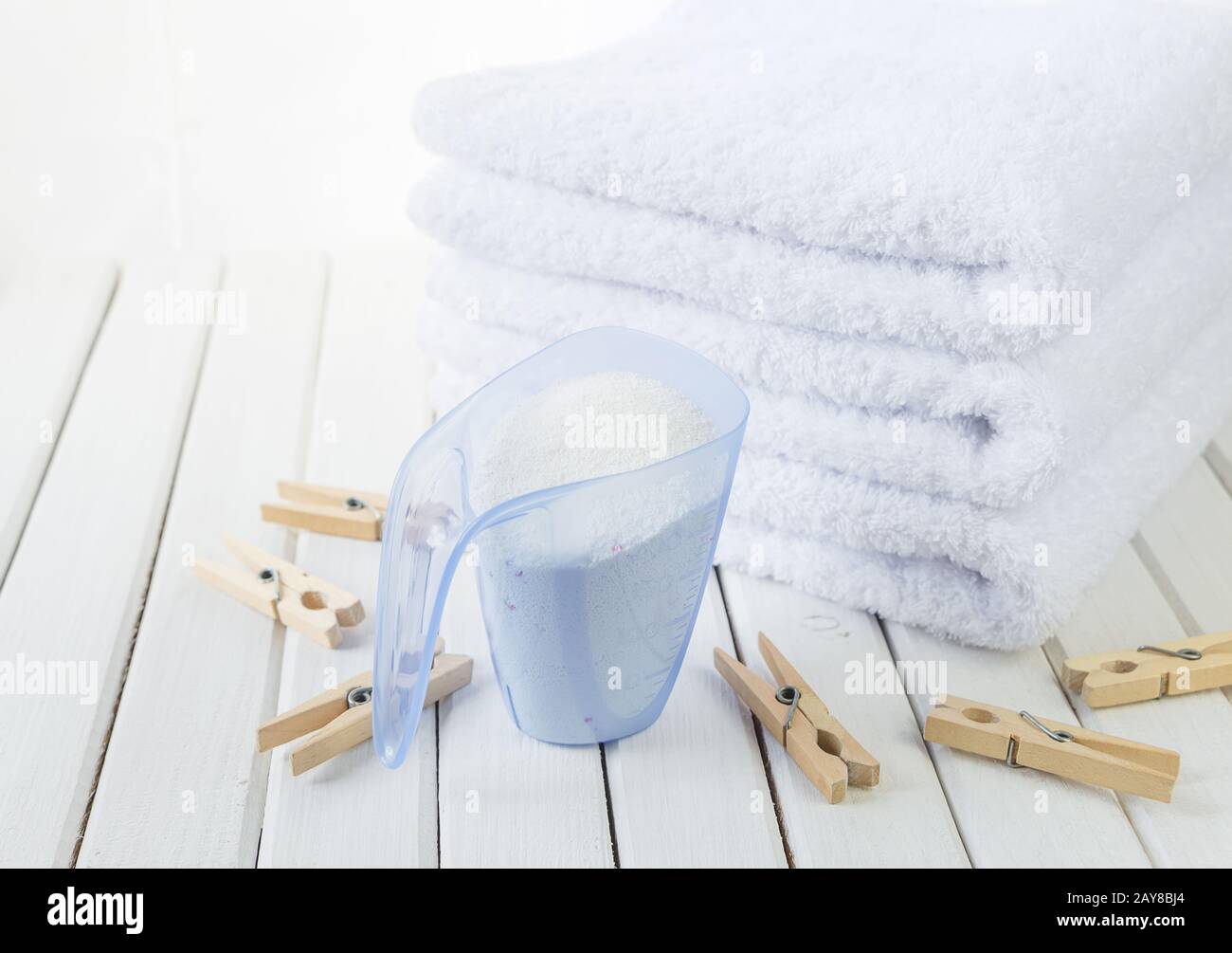 Handtücher, Waschpulver in Messbecher und Holzkleidereppen Stockfoto