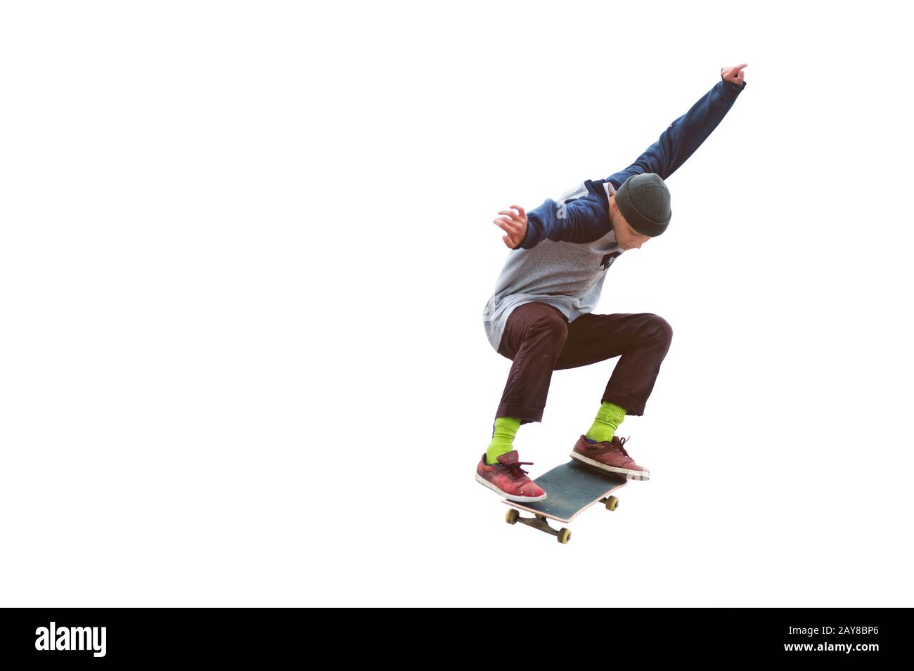 Ein Teenager-Skateboarder springt auf einem isolierten weißen Hintergrund eine Ollie. Das Konzept des Straßensports und der städtischen Kultur Stockfoto