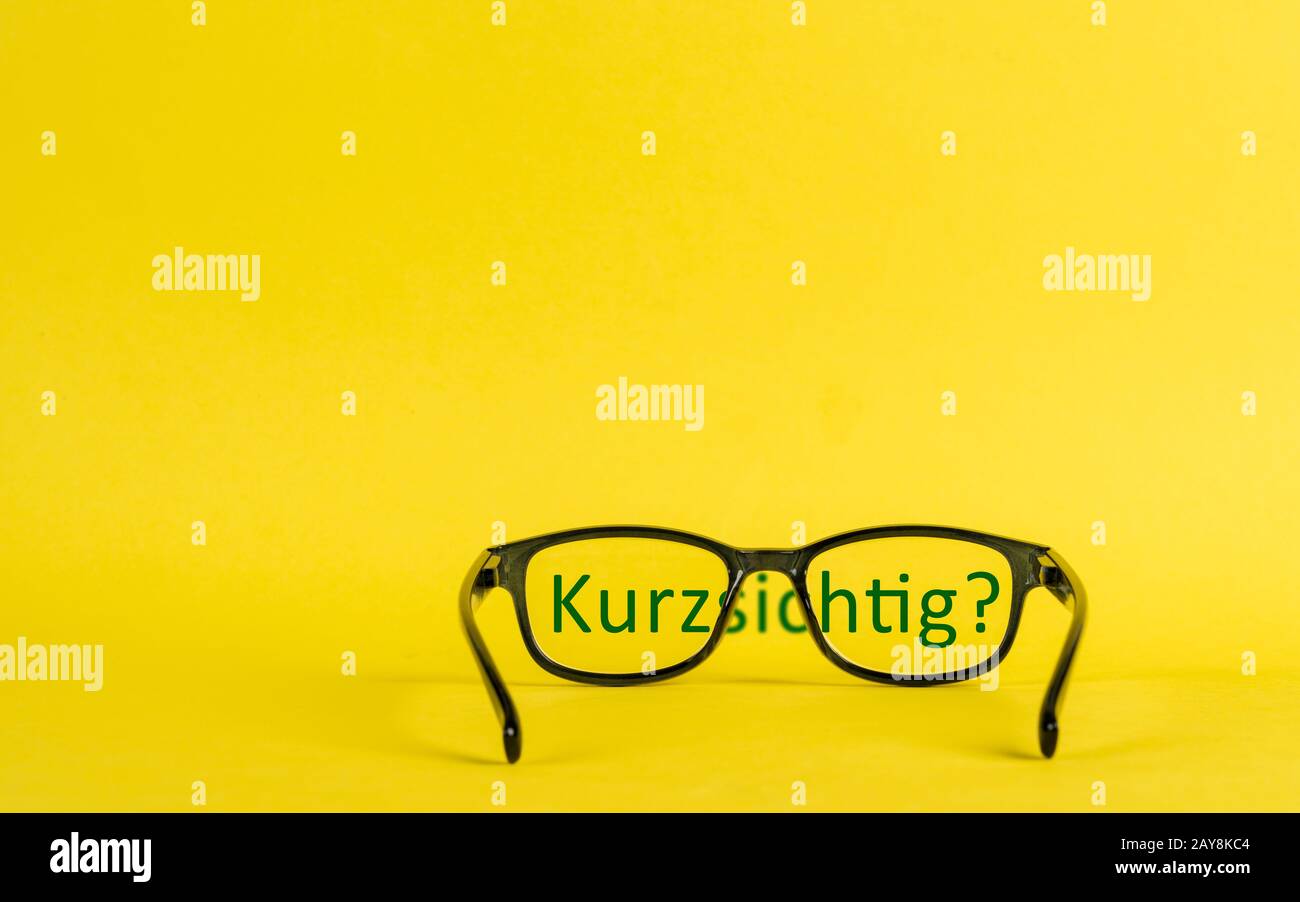 Konzept der mit Brille und verschwommenem Text dargestellten Nahsichtigkeit Stockfoto