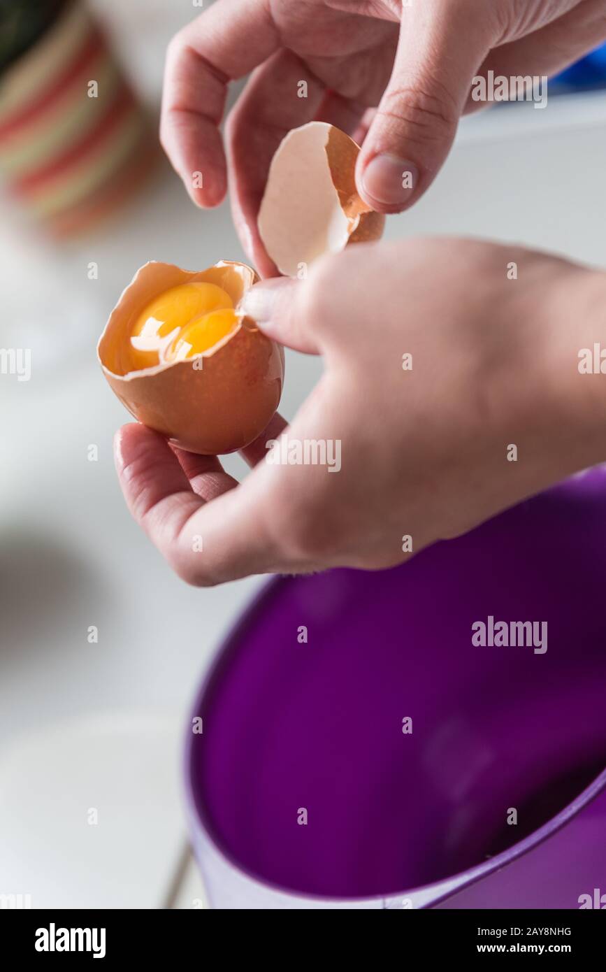 Überraschung beim Öffnen eines Eies mit zwei Eigelb - Nahaufnahme Stockfoto