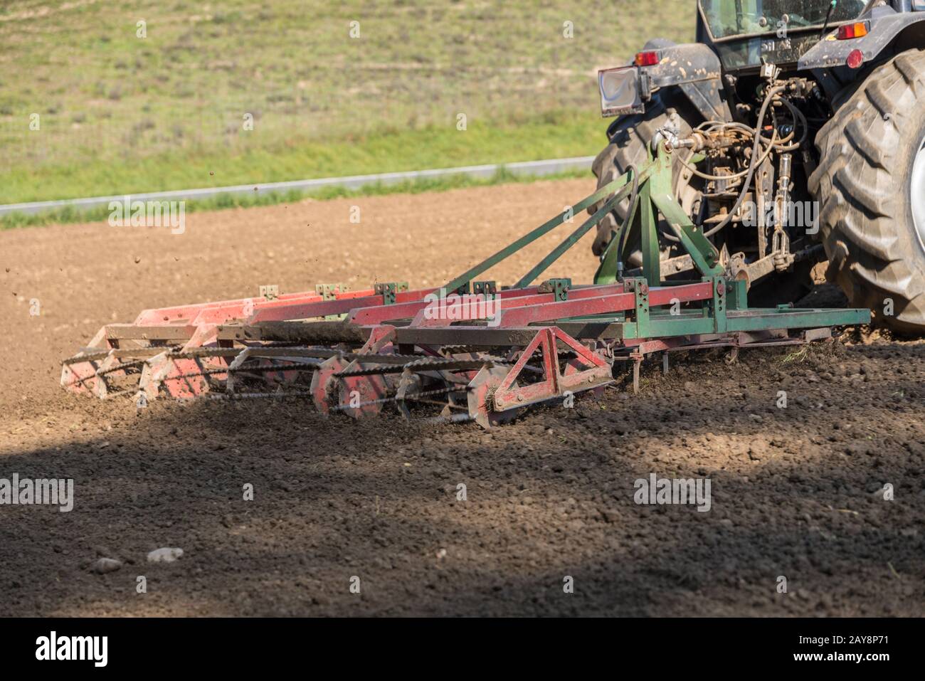 Feldbau mit Traktor und Egge - Nahaufnahme Stockfoto