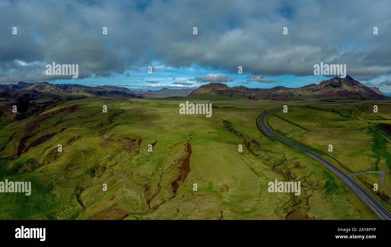 Isländische Landschaft im Sommer mit einer Straße, die durch eine märchenhafte Landschaft führt Stockfoto