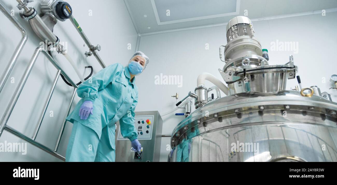 Pharmazeutischen Fabrik Frau Arbeiter in Schutzkleidung die Produktionslinie in steriler Umgebung Stockfoto