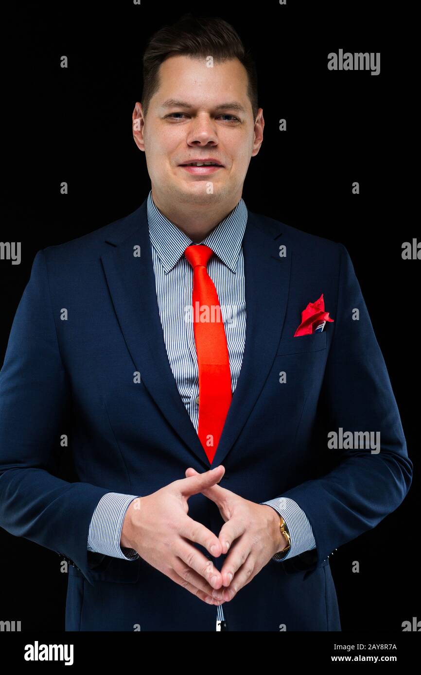 Portrait von zuversichtlich gut aussehender Geschäftsmann denken auf schwarzem Hintergrund Stockfoto