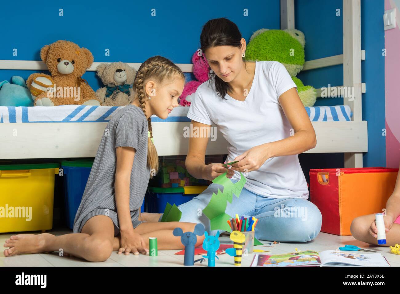 Mama hilft meine Tochter ausgeschnitten Zahlen aus farbigem Papier Stockfoto