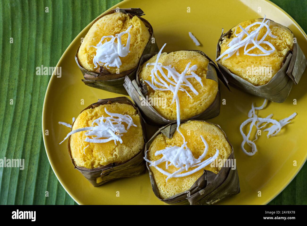 Gelbe Kuchen aus Reismehl und Taro in Bananenblätter eingewickelt Stockfoto