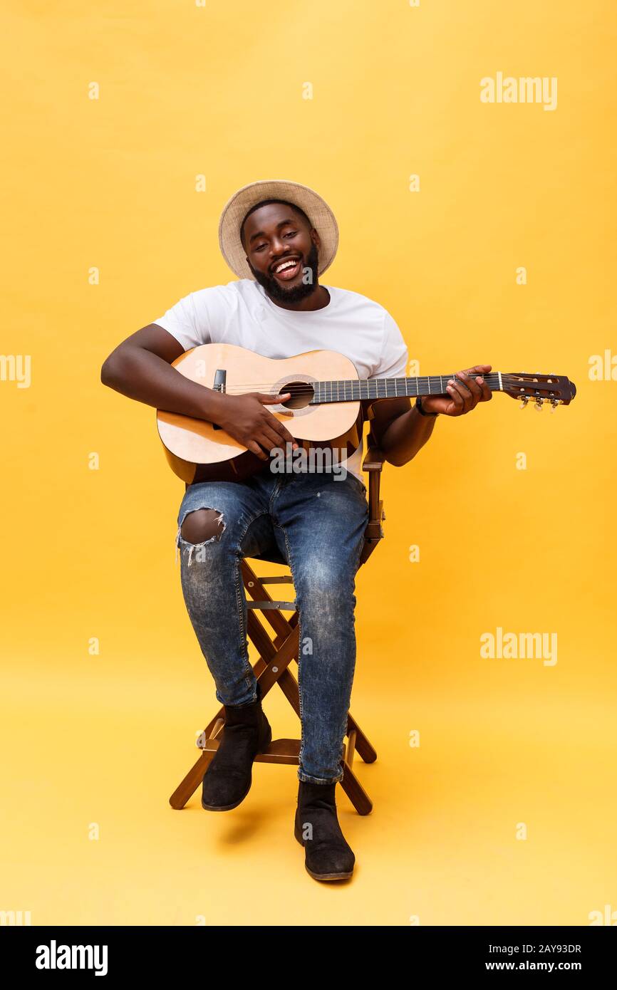 In voller Länge Foto von Angeregten künstlerische Mann, der seine Gitarre spielen. Auf gelben Hintergrund. Stockfoto