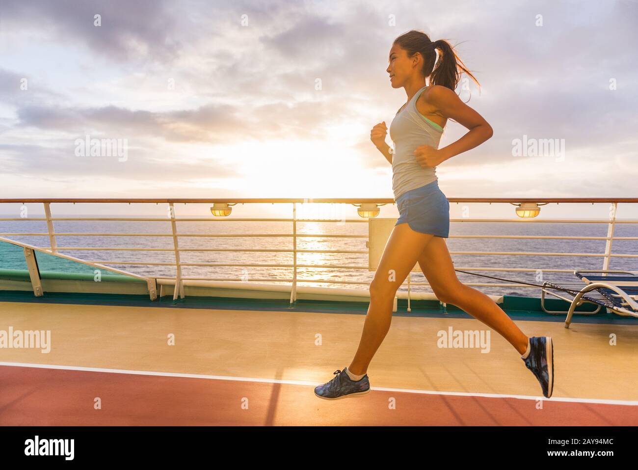 Kreuzfahrtschiffpassagiere machen morgendliches Joggen auf Laufstrecken mit Sonnenaufgang. Frau Tourist, die während des karibischen Reiseurlaubs ein Fitness-Training genießt. Stockfoto