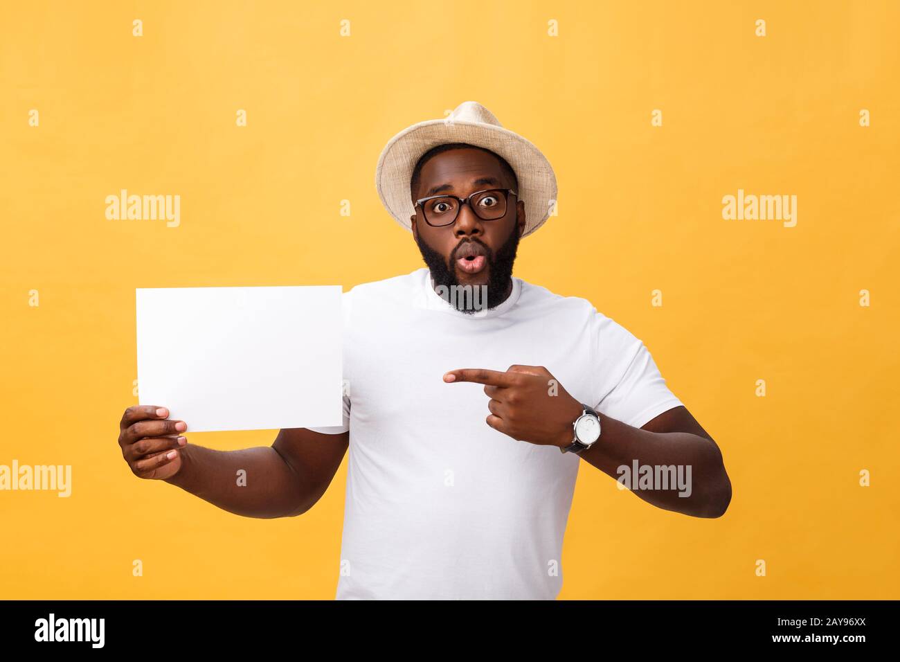 Bild der junge lächelnde afrikanisch-amerikanischen Mann, weiß Blank Board und zeigen auf der gelben Hintergrund, Kopie Raum Stockfoto