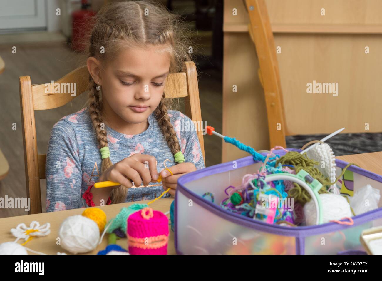 Mädchen häkelt in einem Klassenzimmer in der Schule Stockfoto