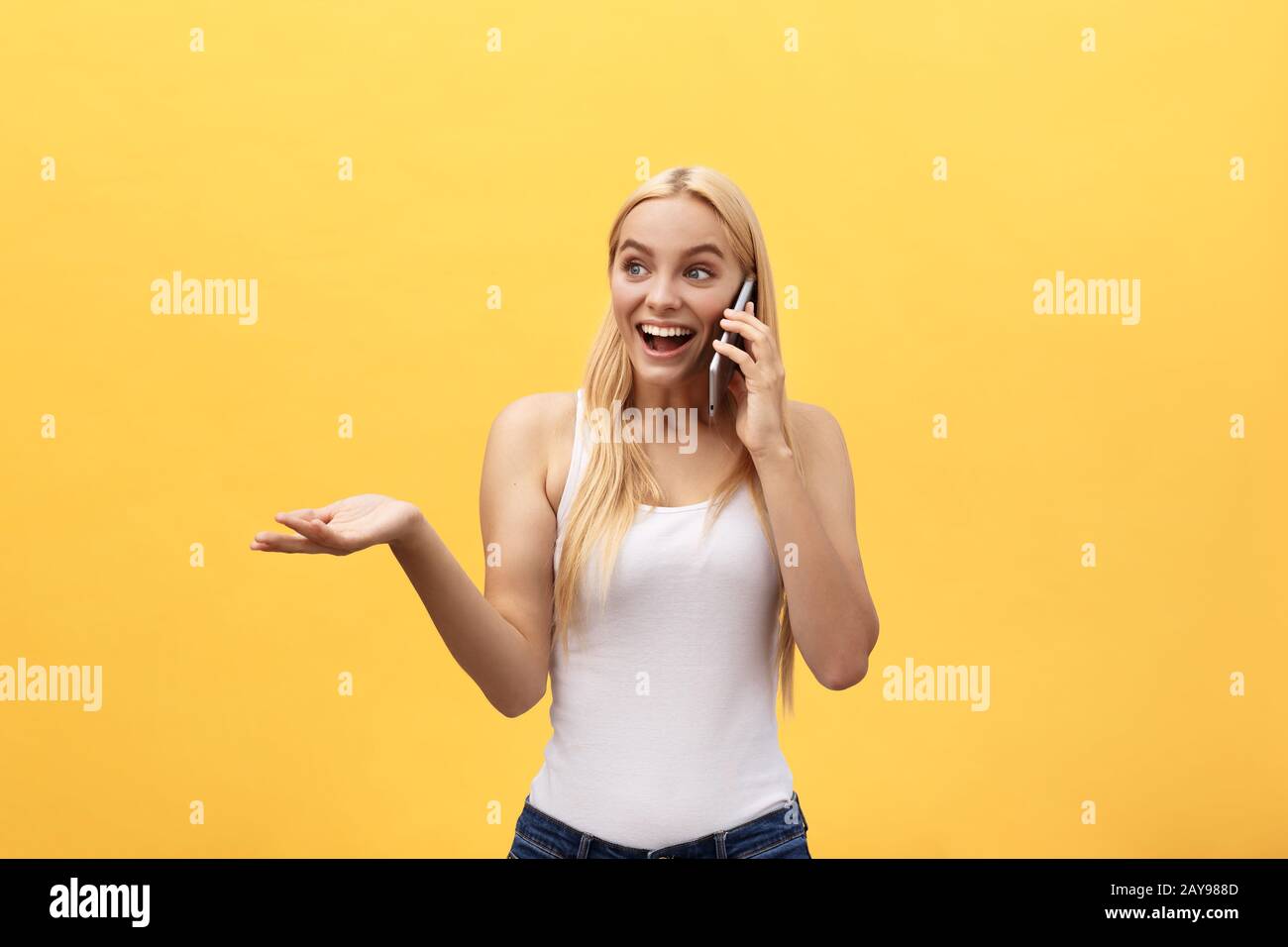 Bild der wunderschönen Frau in ungezwungener überrascht oder begeistert angenehmes Gespräch auf Ihrem Handy zu empfangen, auf gelbem Hintergrund Stockfoto