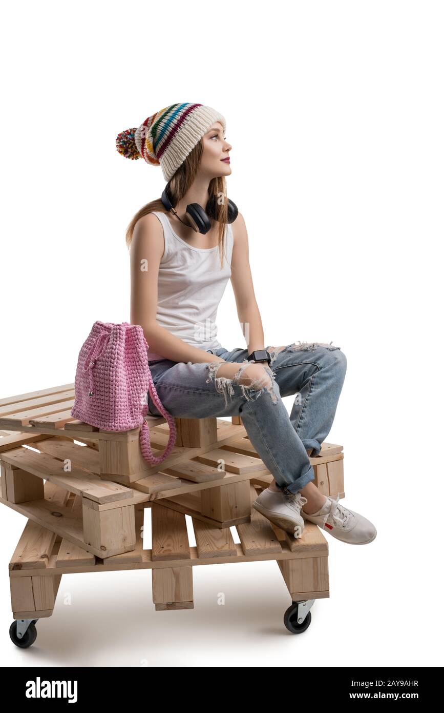 Trendige Frau, die auf Holzpaletten sitzt Stockfoto