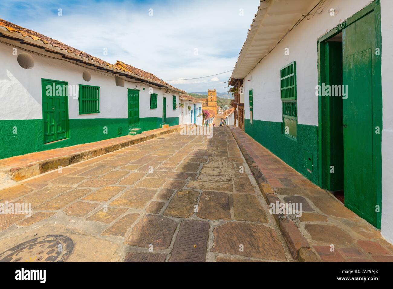 Fünfte Straße mit Kolonialhäusern und Kathedrale im Hintergrund Barichara Kolumbien Stockfoto