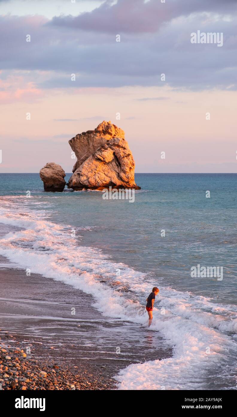 Ein Junge spielt am Strand an den Felsen Petra tou Romiou, in Paphos, Zypern. Stockfoto