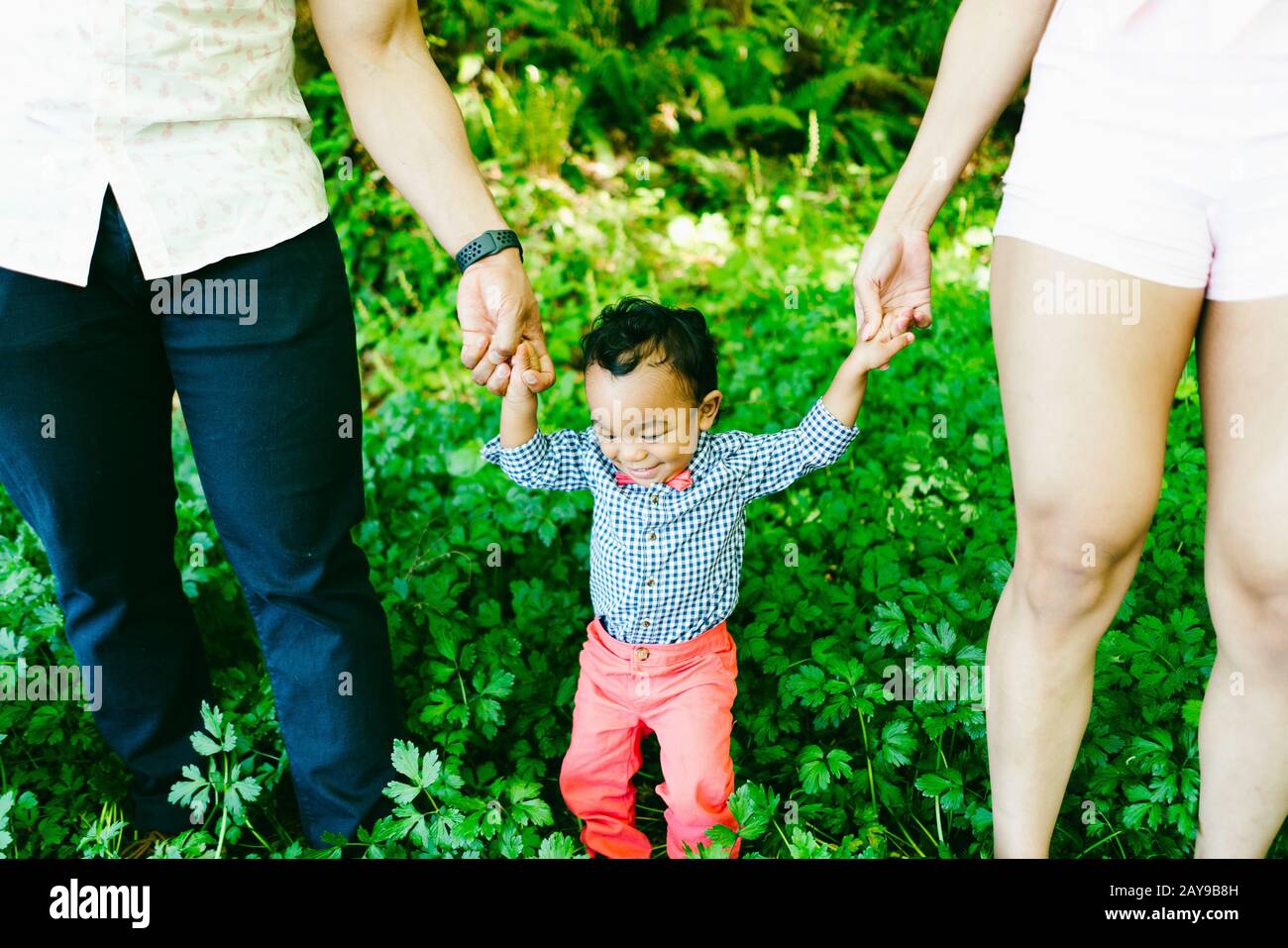 Zugeschnittene Ansicht eines Vaters und einer Mutter, die die Hände ihres Sohnes halten Stockfoto