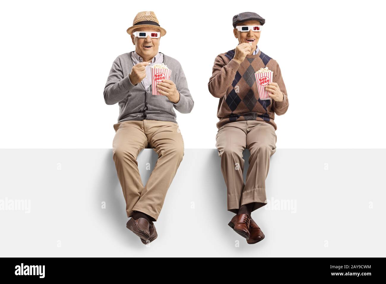 Zwei ältere Männer sitzen auf einem Panel, die Popcorn essen und einen Film mit 3D-Brille ansehen, die auf weißem Hintergrund isoliert ist Stockfoto
