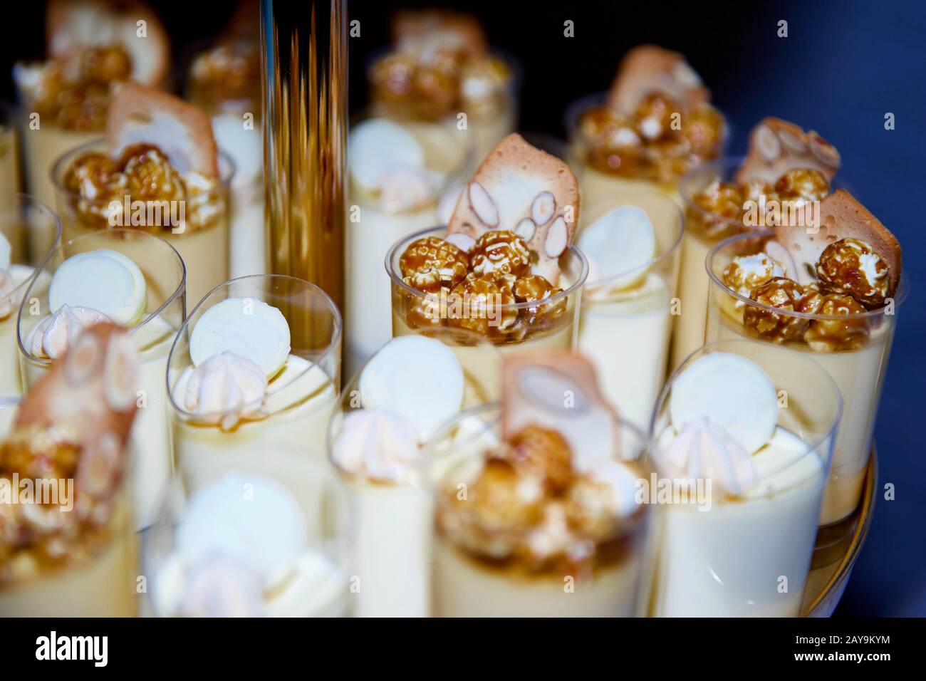 Pudding Tassen mit karamellisiertem Popcorn, Mandelbrot oder Süßigkeiten. Stockfoto