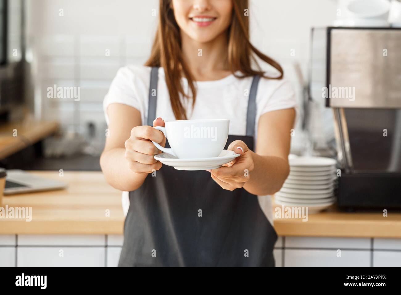 Coffee Business Concept - kaukasische Frauen, die Kaffee servieren, während  sie im Café stehen. Konzentrieren Sie sich auf weibliche Hände, die eine  Tasse mit legen Stockfotografie - Alamy