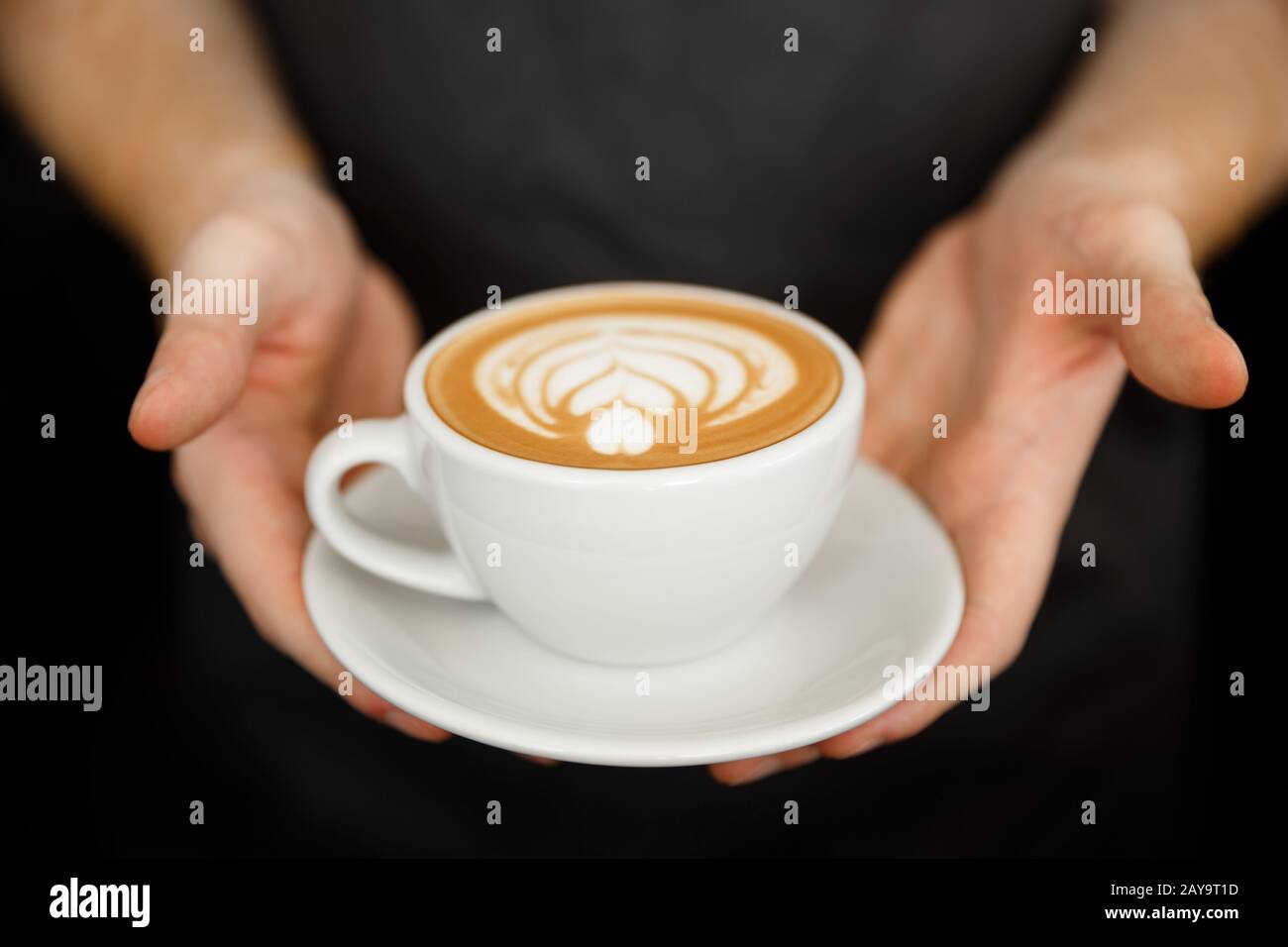 Coffee Business Concept - Nahaufnahme von weiblichen Kaffeespezialitäten mit Latte Art im Coffeeshop. Fokus auf Femal Stockfoto