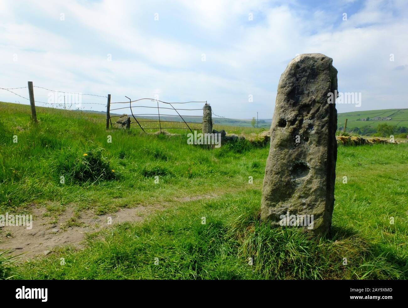 Hoher Stehstein oder alter Gatepost mit altem Fechten und Metalltor im pfenniner Weideland Stockfoto