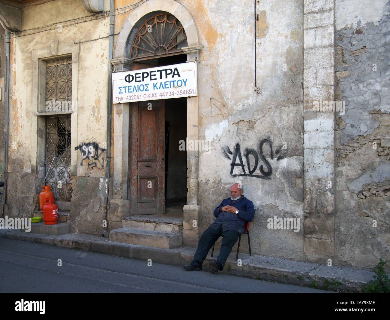 Ein Sargmacher, der sich außerhalb seiner Werkstatt in einem alten zerfallenden Gebäude in Nikosia im Norden zyperns aufhält Stockfoto