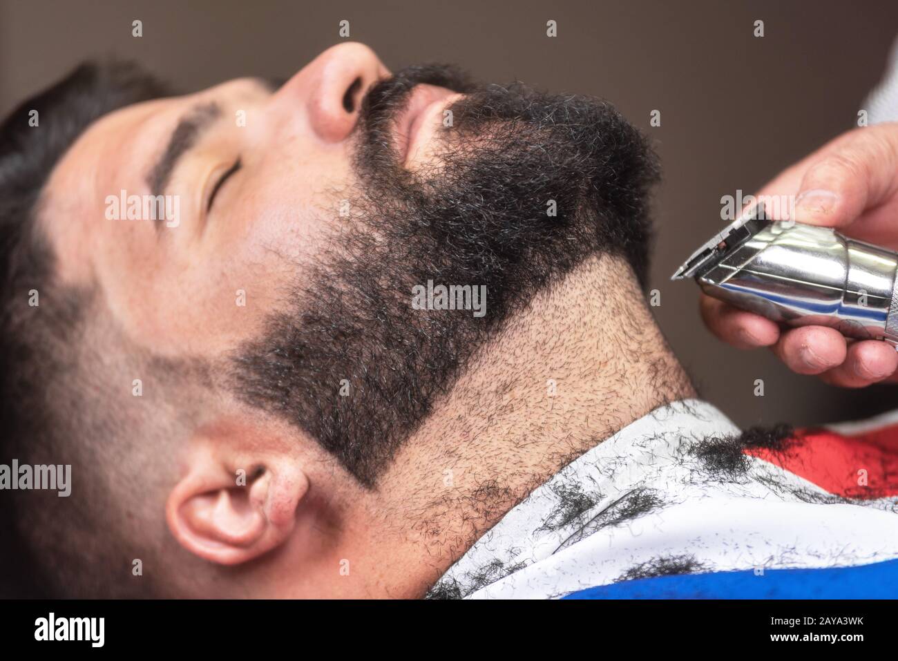 Barber rasiert den Bart eines gutaussehenden bärtigen Mannes mit einem  elektrischen Rasierer im barber Shop Stockfotografie - Alamy