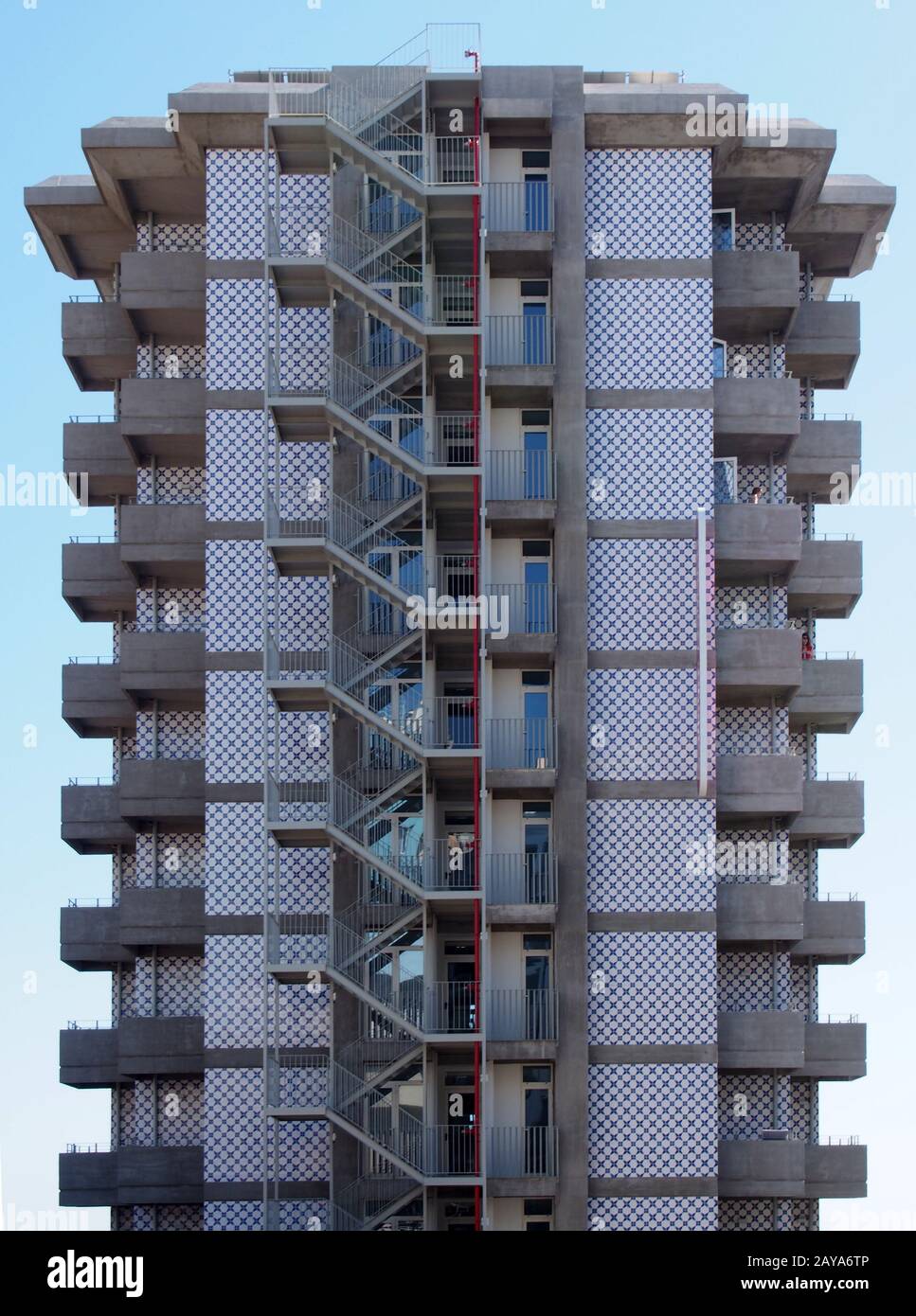 Ein alter hoher Wohnblock aus Beton mit sich wiederholenden Balkonen aus Beton und einer Außentreppe mit Metallgeländern entweichen wieder Stockfoto