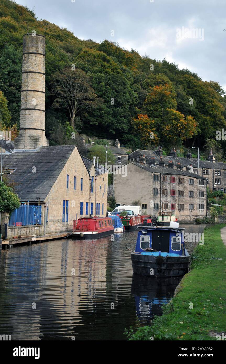 Malerische Aussicht auf die brücke von hebden mit historischen Gebäuden entlang des Kanals und vermoorten Hausbooten mit Schleppbahn und umliegendem Wald Stockfoto