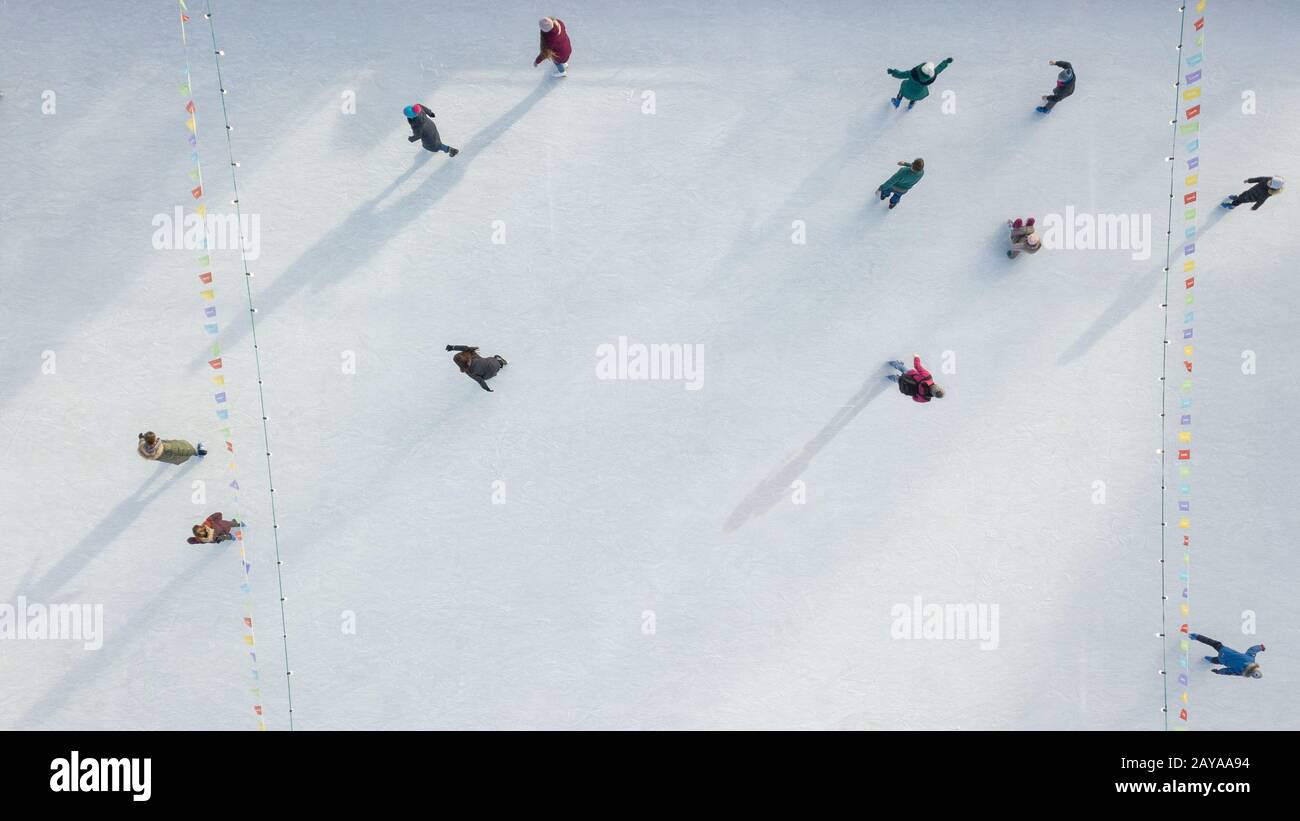 Outdoor Eislaufplatz mit Menschen reiten auf einem Wintertag. Luftbild von der Drohne. Stockfoto