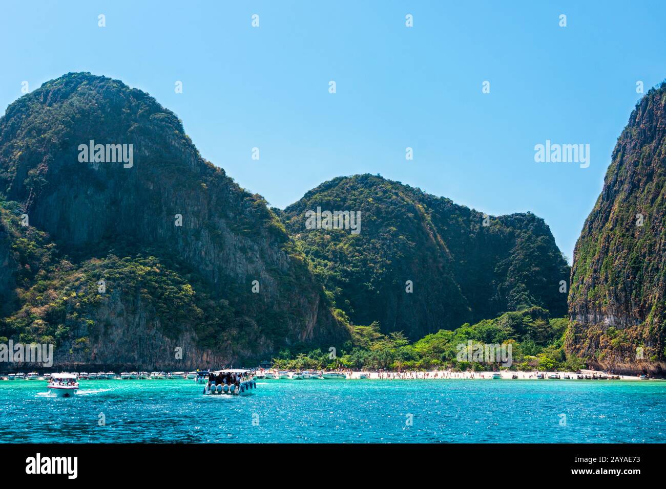 Touristen und Schnellboote in der Maya Bay, dem berühmten Strand der Phi Phi Inseln in Thailand Stockfoto