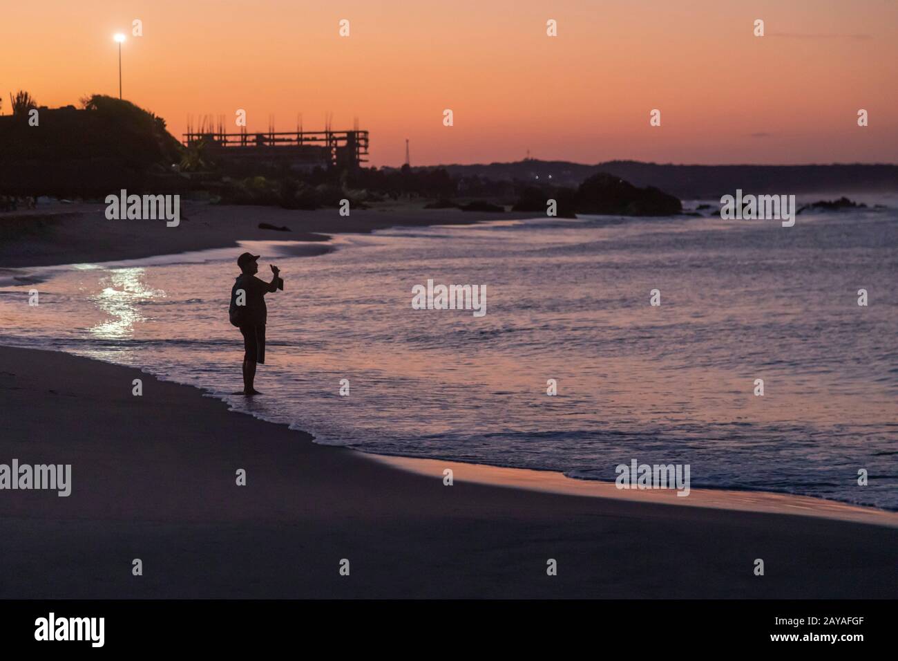 Puerto Escondido, Oaxaca, Mexiko - EIN Mann fischt vor der Morgendämmerung am Playa Principal oder am Hauptstrand am Pazifischen Ozean. Stockfoto