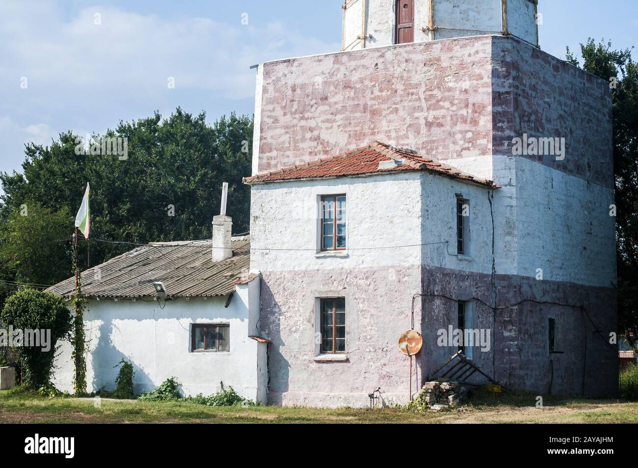Haus an der Unterseite des alten großen marinen Leuchtturm closeup im sonnigen Sommertag Stockfoto