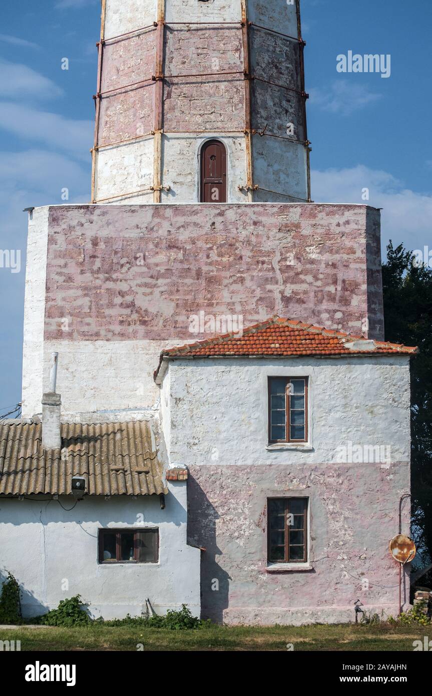 Haus an der Unterseite des alten großen marinen Leuchtturm closeup im sonnigen Sommertag Stockfoto