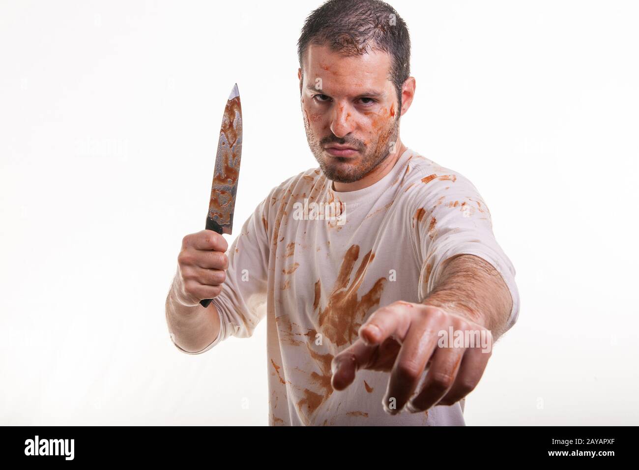 Eine blutige Szene mit einem Mann und einem blutüberzogenen Messer in der Hand isoliert auf weißem Hintergrund. Violen Stockfoto